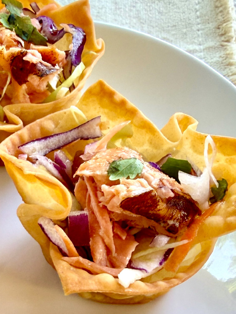 Three Crispy Salmon Cups topped with California King Salmon and fresh slaw served as a seafood appetizer.
